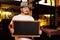 A fat cheerful man in a Bavarian hat with a feather during the celebration of Oktoberfest holds a sign or chalkboard in