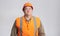 Fat construction worker in funny confusion in helmet on grey background, bulder does not understand with humorous face expression