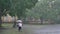 Fat ginger girl is running in park under rain, holding umbrella