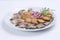 Fat herring slices served on a plate with sliced fried potatoes, sprinkled with spices and decorated with arugula