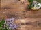 Fat lay with a bouquet flowers lilac.Decoration white birdcage on wooden slice on brown wooden background