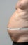 Fat male stomach in profile with tape measure