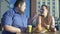 Fat male treating girlfriend with fries couple eating junk food, obesity problem