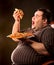 Fat man eating fast food slice pizza . Breakfast for overweight person.