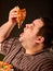 Fat man eating fast food slice pizza . Breakfast for overweight person.