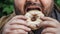 Fat man eats donut on street, close up. Unhealthy glazed sweet fast food