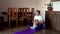 Fat man and pomeranian dog doing gymnastics at home on mat. Man in lotus position back sitting meditates dzen. Doing fitness with