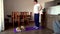 Fat man and pomeranian dog doing gymnastics for losing weight at home on mat on floor. Doing fitness with your dog. Overweight guy