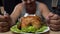 Fat man preparing to eat greasy fried chicken, holding knife and fork, close-up