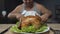 Fat man preparing to eat greasy fried chicken, holding knife and fork, close-up