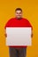 Fat man in red t-shirt displaying a white banner ad isolated over a yellow background.