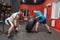 Fat man is very persistent doing tyre flipping exercise in the gym under guidance of personal coach. Overweight