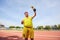 A fat man with a winner`s cup in his hands at the stadium.