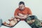 Fat Upset Man with Trays With Food on White Table.