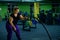 Fat woman doing strength training using battle ropes in the gym. An obese athlete moves the ropes in a wave motion to