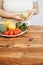 Fat woman snacking with fruits and vegetables