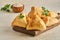 Fatayer pie samosa with white cheese and black sesame seeds on wooden board