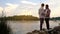 Father and 16 years old son preparing fishing rods, relaxing together near lake