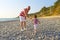 Father and 2 years son in similar clothes walk on the seaside