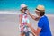 Father apply sunblock cream on his little daughter nose