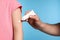 Father applying ointment onto his daughter\'s arm on light blue background, closeup