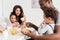 father applying peanut butter on toast for son