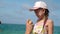 Father applying protective cream to her daughter`s face at the beach. Man hand holding sunscreen lotion on baby face.