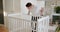 Father with assembling baby bed at home. Slow motion Wide shot