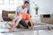 father assisting his daughter to do stretching at home