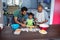 Father assisting son for preparing food while standing by man using tablet