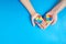 Father and autistic son hands holding jigsaw puzzle heart shape. Autism spectrum disorder family support concept. World