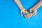 Father and autistic son hands holding jigsaw puzzle heart shape. Autism spectrum disorder family support concept. World