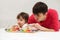 Father and baby girl playing xylophone toy at home