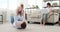 Father with baby son playing on carpet while mother working on laptop