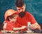 Father with beard and little son in classroom teaching to use tools, chalkboard on background. Mens work concept. Boy