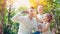 Father blowing soap bubbles for son and little daughter in the park, lifestyle family concept