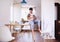 A father bottle feeding a small toddler son indoors at home.