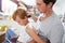 Father Brushing Son\'s Hair At Breakfast Table