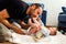 Father changing his baby`s diaper while caressing him affectionately