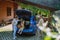 Father charging their electric car, little daughter and mother waiting in a car trunk.