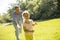 Father chasing his little daughter while playing in the park