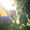 Father, child and hammer tent for camping outdoor in nature on vacation, bonding together and sunset. Dad, boy and