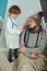 Father and child playing clinic and doctor, little boy in medical gown with stethoscope treats dad