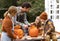 Father and children carving pumpkin for halloween in backyard