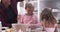 Father With Children Having Messy Fun Baking In Kitchen