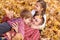 Father and children are lying on yellow leaves and having fun in autumn city park. They posing, smiling, playing. Bright yellow tr