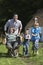 Father And Children Racing With Wheelbarrow Outside Cottage