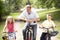 Father and children riding bikes in countryside