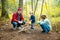 Father and children roasting marshmallows on sticks at bonfire. Children having fun at camp fire. Camping with kids in fall forest