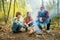 Father and children roasting marshmallows on sticks at bonfire. Children having fun at camp fire. Camping with kids in fall forest